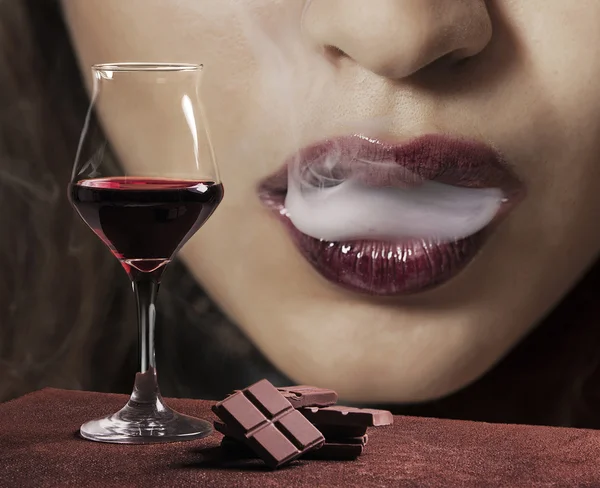 Copo de vinho tinto com chocolate e boca feminina fumar — Fotografia de Stock