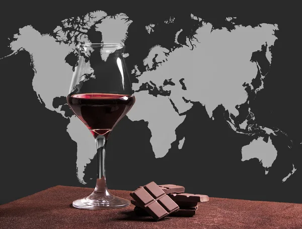 Red wine glass with chocolate and world map — Stock Photo, Image