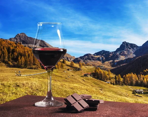 Copa de vino con chocolate y hermoso paisaje montañoso de otoño — Foto de Stock