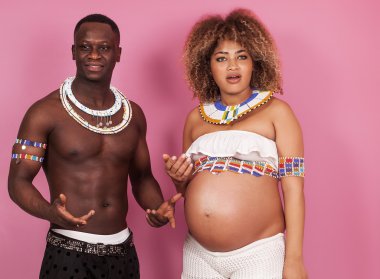 Komik çift portre bekliyor bebek pembe bir arka plan üzerinde