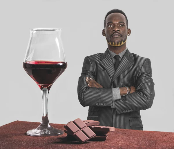 Red wine glass and chocolate with businessman with crossed arms — Stock Photo, Image