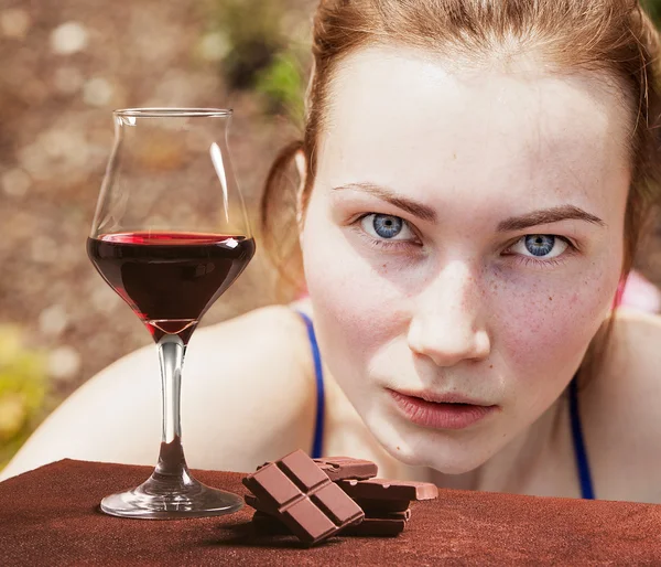 Copa de vino tinto y chocolate con retrato de chica hermosa — Foto de Stock
