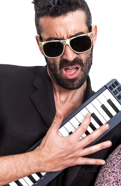 Красивый мужчина в солнечных очках и играет на клавиатуре — стоковое фото
