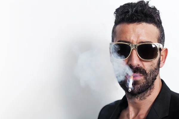 Przystojny mężczyzna nosi okulary i palenia papierosów — Zdjęcie stockowe