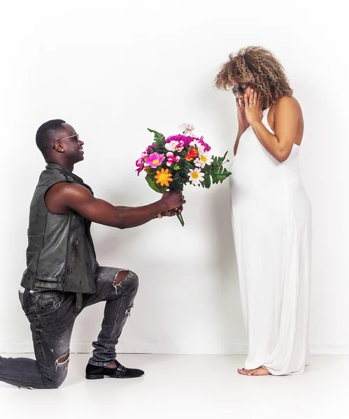 Schöner Mann schenkt seiner schwangeren Freundin Blumen — Stockfoto