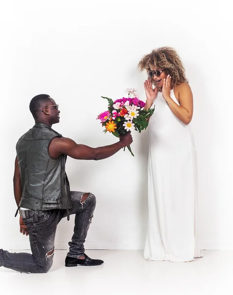 Porträt eines Mannes, der seiner schwangeren und überraschten Freundin Blumen schenkt — Stockfoto