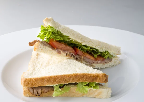 Yeşil salata ve domates ile servis etli sandviç