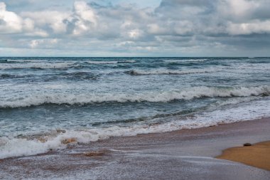 Boş sahil ve bulutlu havada fırtınalı deniz