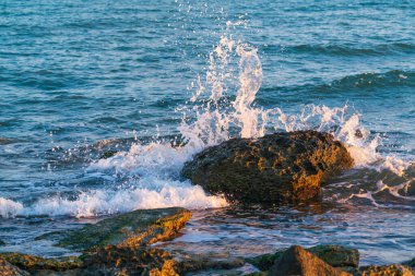 Büyük taş ve dalgalar deniz kıyısına vuruyor.