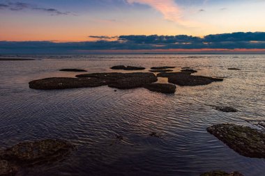 Kayalık sahilde renkli gün doğumu