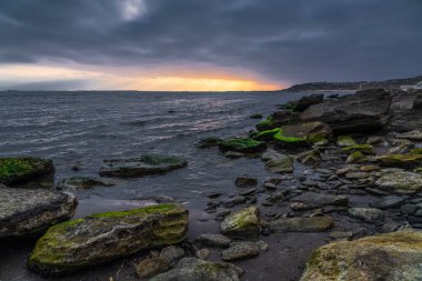 Deniz kıyısında kasvetli gün doğumu