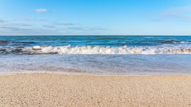 Sarı kumlu ve mavi dalgalı boş sahil, tatil köyünde karantina.