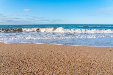 Sarı kumlu ve mavi dalgalı boş sahil, tatil köyünde karantina.