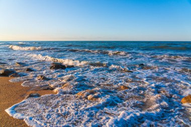 Sarı kumlu ve mavi dalgalı boş sahil, tatil köyünde karantina.