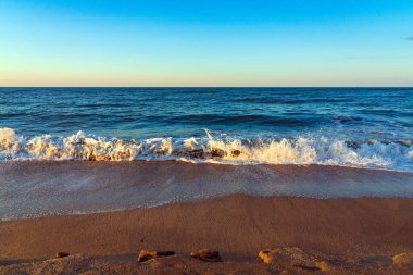 Sarı kumlu ve mavi dalgalı boş sahil, tatil köyünde karantina.