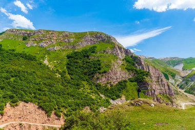 Dağlarda fotoğraf makinesi ve sırt çantası olan bir gezgin.