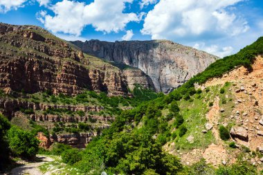 Yüksek görkemli uçurumlar ve bulutlu mavi gökyüzü