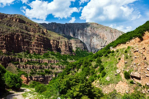 Yüksek görkemli uçurumlar ve bulutlu mavi gökyüzü