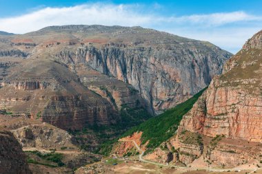 Yüksek görkemli uçurumlar ve bulutlu mavi gökyüzü