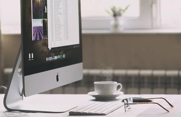 iMac bilgisayar ve gözlükler masanın üstünde.