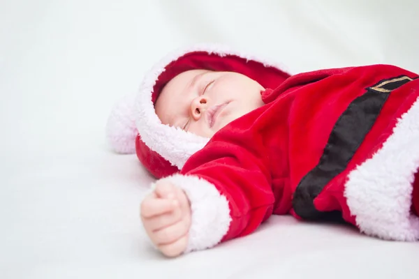 Söt baby sover i röd och vit jul Santa sui — Stockfoto