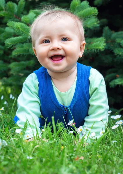 Söta leende lilla barnet ligger på ett färskt grönt gräs i paritet — Stockfoto
