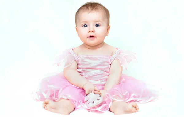 Bedårande liten flicka i rosa klänning leker med hennes rosa sho — Stockfoto