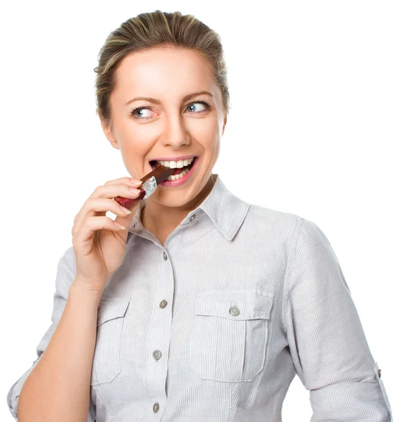 Portret van een jonge vrouw bijten chocolade op wit wordt geïsoleerd — Stockfoto