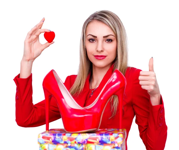 Young beautiful woman happy to receive red high heels shoes as a present and showing thumb up gesture — Stock Photo, Image
