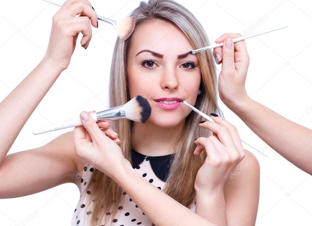 Make up woman with many hands. Makeup brushes. Isolated on whit