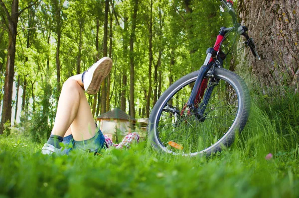 Giovane ciclista relax sdraiato sull'erba — Foto Stock