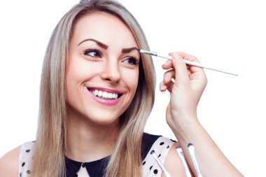 Whit üzerinde izole kadın, yüzünde göz farı uygulamak makyaj sanatçısı