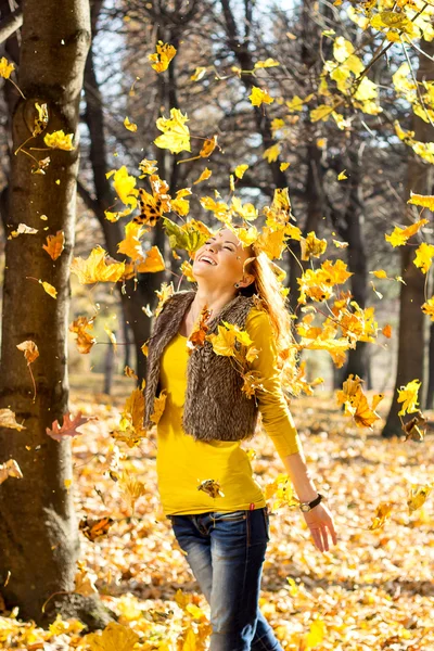 Glücklich lächelnde junge Frau mit einem Bund gelb gefärbtem Ahornblatt — Stockfoto