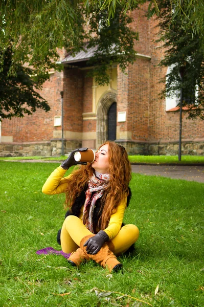 秋の公園でお茶のカップを持つ若い女性 — ストック写真