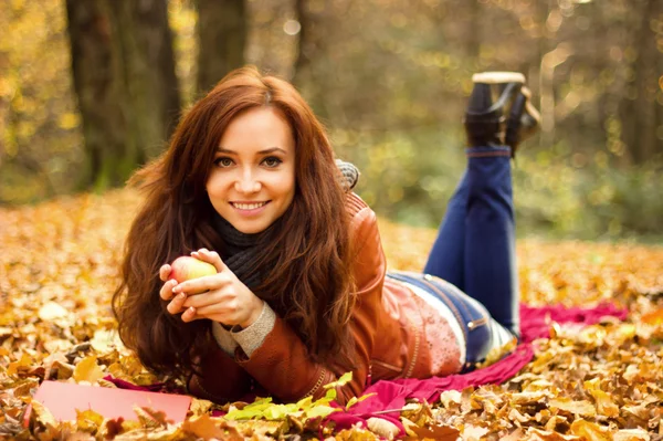 Glückliche junge Frau mit Buch und Apfel — Stockfoto