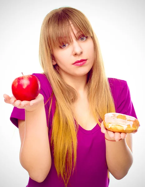 Woman choosing between fruit and sweets — Stock Photo, Image