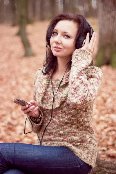 Молодая девушка слушает музыку в парке — стоковое фото