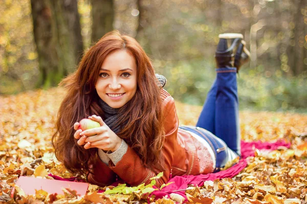 Glückliche junge Frau mit Buch und Apfel — Stockfoto