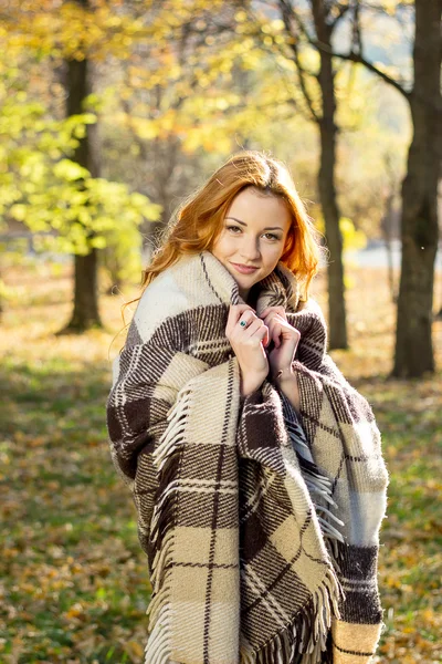 年轻漂亮的女孩在公园里覆盖在格子秋季的一天 — 图库照片