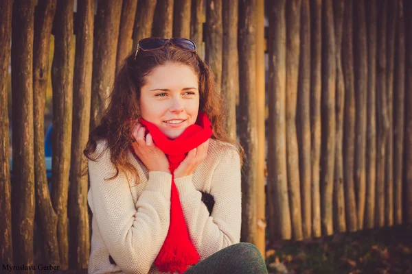 Schöne Herbst Frau sitzt im Park im roten Hai — Stockfoto