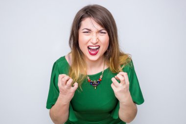 Kızgın bir kadın çığlığı yeşil zarif elbisenin içinde closeup poz
