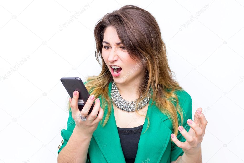 woman wearing in green jacket   shouts in anger to her phone,  woman  cries in the mobile phone