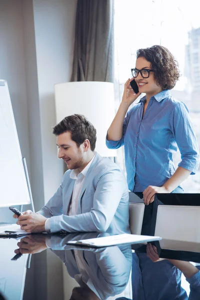 Pleasant colleagues holding cell phones — Stock Photo, Image