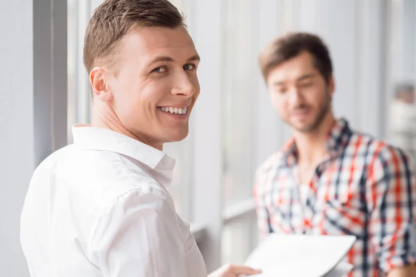 Cheerful man standing with his colleague — Stock Photo, Image