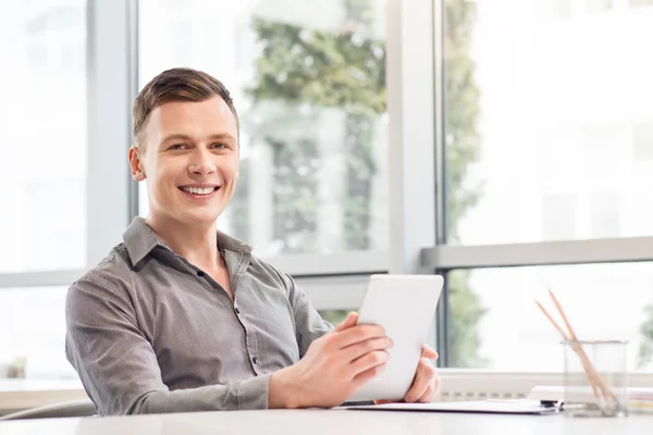 Hombre alegre sosteniendo la tableta — Foto de Stock