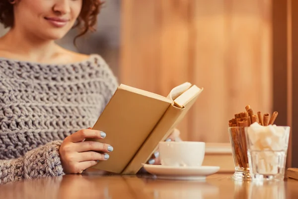 Pleasant woman reading book in the cafe — Stock Photo, Image