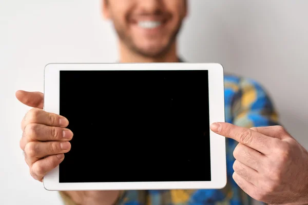 Tablet in den Händen eines lächelnden Mannes — Stockfoto