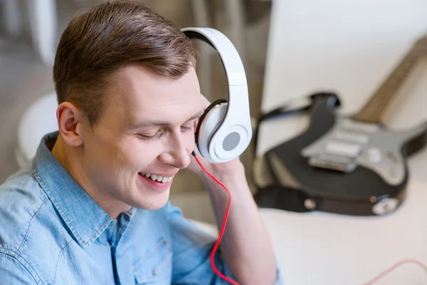 Fröhlicher Typ, der Musik hört — Stockfoto