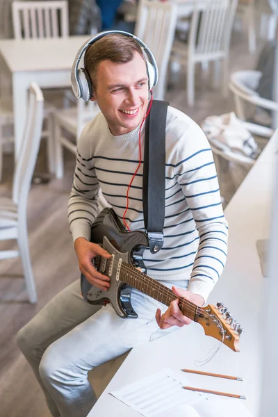 Cheerful guy playing the guitar