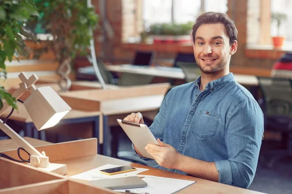 Agradable hombre sentado a la mesa — Foto de Stock